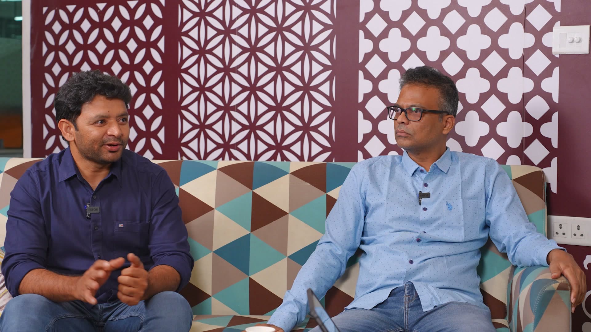 Srinivas Reddy mid-sentence, hands up, with Siva Nalavenkata listening, on a sofa at T-Hub Hyderabad